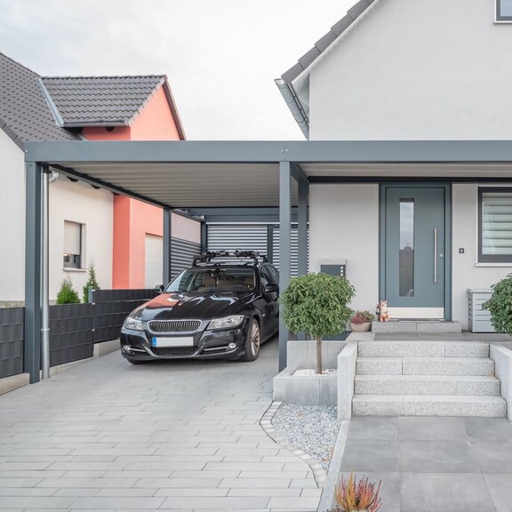 Moderner Stahlcarport an Einfamilienhaus Carport_mit_Stahlwelle_und_Eingangsueberdachung.jpeg